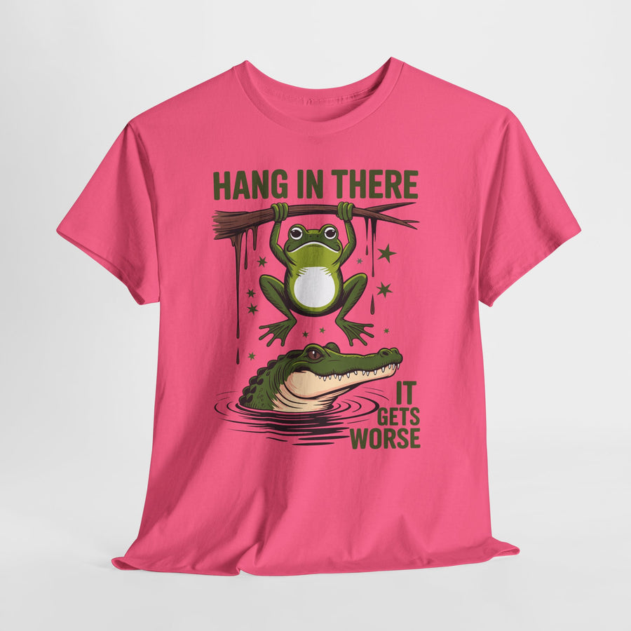 Pink t-shirt with a graphic of a frog and alligator with text 'Hang in there, it gets worse' on a white background.